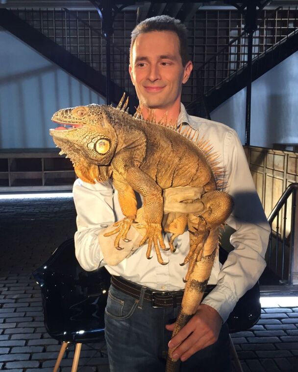 Karim Daoues portant un gros Iguane vert